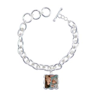 Bracelets: A silver link charm bracelet with a square, wavy-edged photo charm of a mother and baby.