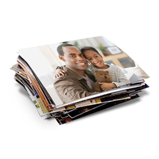 Same Day 1hr Prints: A stack of photo prints with the top photo showing a father and son holding a teddy bear.