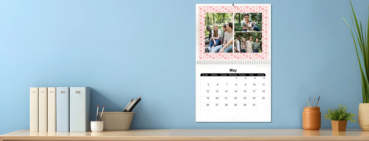 shop same-day 8.5x11 wall calendar: A personalized wall calendar hanging on a wall, showing a photo collage for the month of May.
