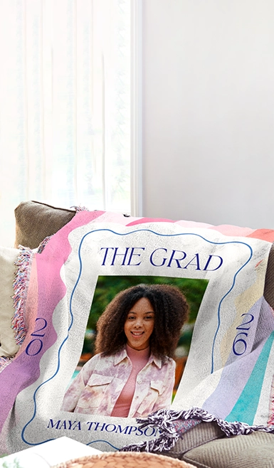 A personalised photo blanket draped in a cosy living room setting, showcasing a custom print design