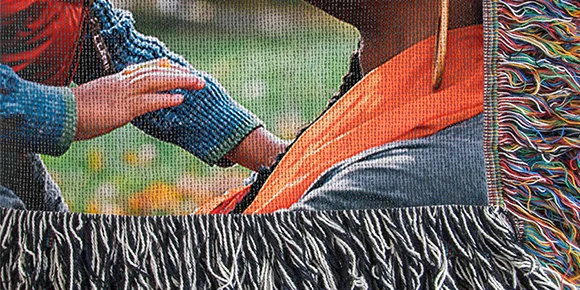 Woven photo blanket featuring intricate texture and fringed edges.