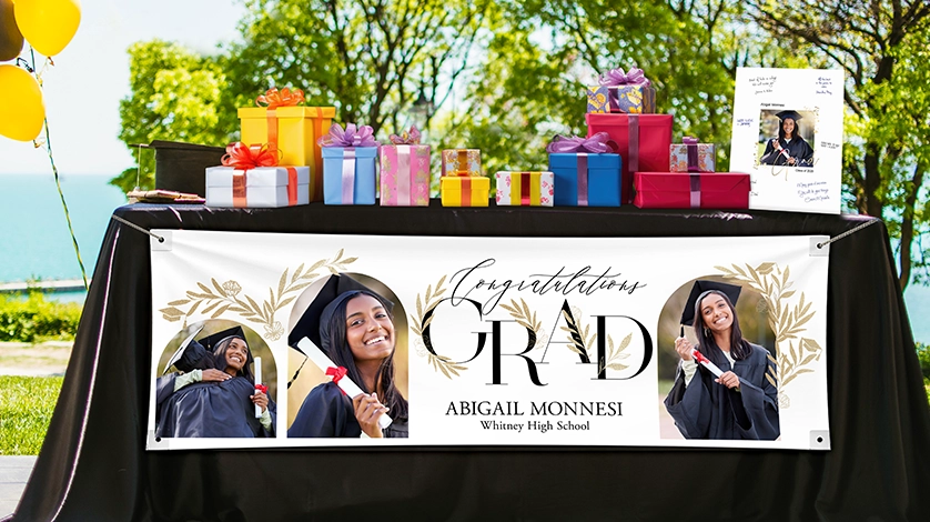 imaBig Moments Deserve Big Banners: A large graduation banner with a photo collage and the text graduate Class of 2026 Emerson Drew Webster, displayed under a neon Congratulations sign with gold and white balloons.ge