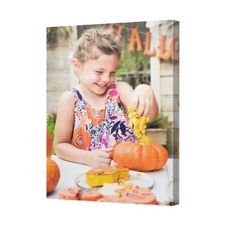 Canvas Prints: A vertical canvas print with a photo of a girl carving a pumpkin.